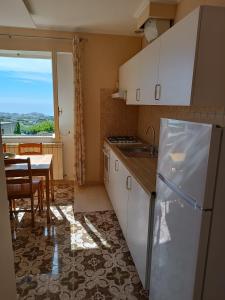 a kitchen with a refrigerator and a table and a window at Il rosmarino in Ischia
