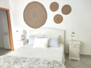 a bedroom with a white bed with hats on the wall at Casa Dama in Vietri sul Mare