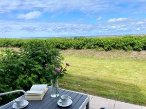a table with a vase of flowers on top of a patio at Haus Kampbarg Suite 2-Meer-Blick in Kampen