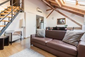 sala de estar con sofá marrón y escalera en Riverside Palace Apartments, en Praga