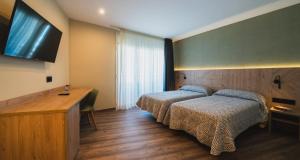 A bed or beds in a room at Hotel Jardí Apartaments