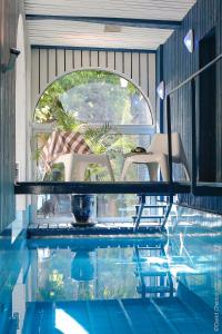 - une piscine avec 2 chaises, une table et de l'eau dans l'établissement La Cour Berbisey - Teritoria, à Dijon