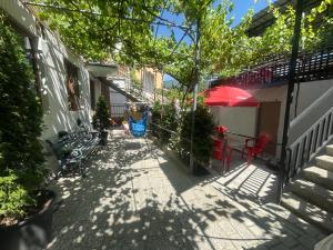 a patio with a table and a red umbrella at Guesthouse Saba in Borjomi +8 photos