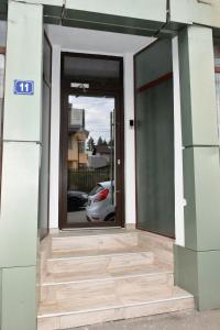 una puerta abierta de un edificio con un reflejo de un coche en Flamingo Hotel, en Piteşti