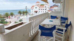 a balcony with a table and chairs and a view of the ocean at Catherine's Beachfront Apartment by Optimum Link in Paralia Katerinis