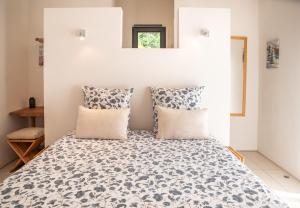 ein Schlafzimmer mit einem Bett mit zwei Kissen in der Unterkunft La Maison du Cotton- Gite bio-climatique in Andernos-les-Bains