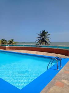 ein Pool mit einer Palme im Hintergrund in der Unterkunft Tucacas Penthouse w Generator and Water Tank in Tucacas