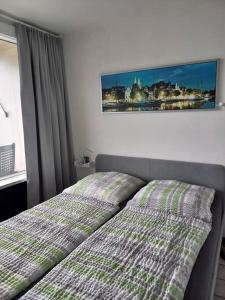 a bedroom with a bed and a picture on the wall at Ferienwohnung mit Ostseeblick & Strandlage in Sierksdorf