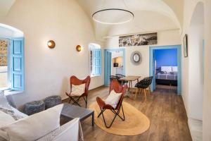 a living room with chairs and a table at Aerie 2bedroom by Thireon in Oia