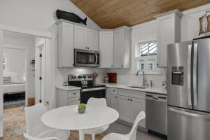 a kitchen with white cabinets and a white table and chairs at Sara Sea by Seabrook Hospitality in Pacific Beach +29 photos
