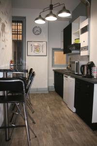 a kitchen with black cabinets and a table and chairs at Chez Mo in Lyon