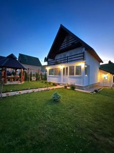 a house with a green lawn in front of it at Guest House SARA in Žabljak
