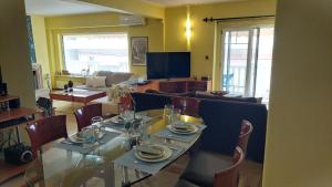 a dining room with a table and a couch at Catherine's Beachfront Apartment by Optimum Link in Paralia Katerinis