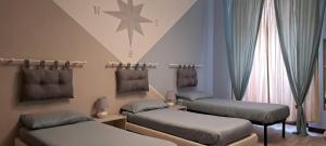 una habitación con 3 camas y una estrella en la pared en B&B Empire 1970, en Trieste