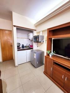 een keuken met een televisie en een keuken met een aanrecht bij Céntrico departamento porteño in Buenos Aires