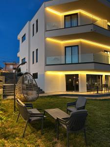 a building with chairs and a playground in front of it at Adele Hotel Ksamil in Ksamil