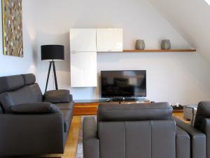 a living room with two couches and a flat screen tv at Moselschön Das Ferienhaus in Brodenbach