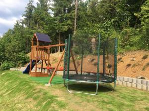 a playground with a swing set in a yard at Chaty pod lesom Oščadnica in Oščadnica