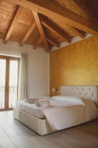 Un dormitorio con una cama grande en una habitación con techos de madera. en Rama Relais, en Caprino Veronese