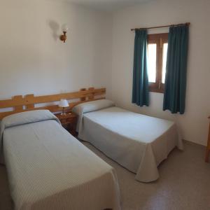 Habitación de hotel con 2 camas y ventana en Can Pep Lluquinet en Es Pujols
