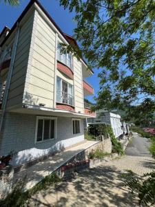 uma casa branca com uma varanda numa rua em Yavuz Luxury Apartments em Macka
