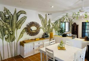 a dining room with a table and some plants on the wall at Sirenas Caribbean Rooms Holbox in Holbox Island