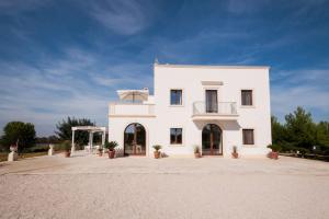 a white building with a balcony on top of it at Tenuta TerraLuna in Collepasso