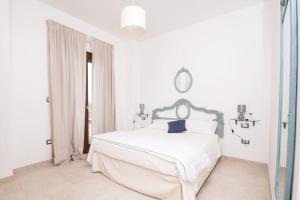 a white bedroom with a white bed and a mirror at Tenuta TerraLuna in Collepasso +26 photos