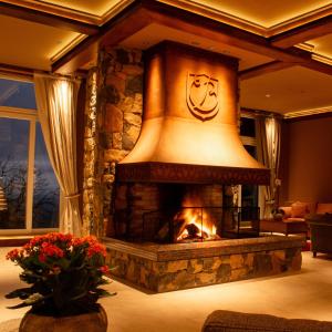 una chimenea en la sala de estar con una gran campana en Villa Bella Hotel & SPA Gramado, en Gramado