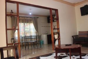 a living room with a table and a dining room at Montane Safaris Hotel in Fort Portal +18 photos