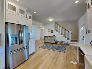 a kitchen with a stainless steel refrigerator and white cabinets at Pelican Landing in North Topsail Beach +28 photos