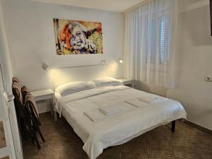 a bedroom with a bed and a painting on the wall at Don Dolfino Guesthouse - Hiša Dolfinova vrata in Piran