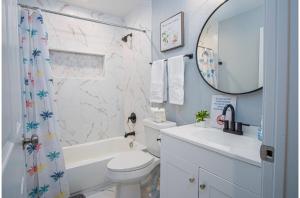 a bathroom with a toilet and a tub and a sink at Spacious Delightful 4 BR 3 BA Close to Downtown in San Antonio +31 photos