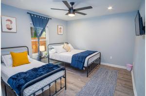 a bedroom with two beds and a ceiling fan at Spacious Delightful 4 BR 3 BA Close to Downtown in San Antonio