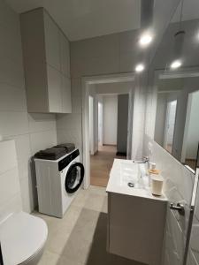 ein Badezimmer mit einer Waschmaschine und einem Waschbecken in der Unterkunft Apartament Chodkiewicza 64 Parking in Bydgoszcz