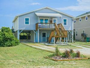 a house with a staircase in front of it at Pelican Perch in Surf City
