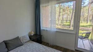 a bedroom with a bed and a large window at Pine forest house 8 in Gauja