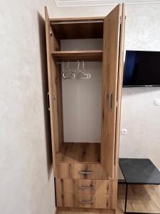 a wooden cabinet with a tv in it at Apartman Studio MiA in Slavonski Brod