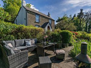 a garden with a couch and chairs in front of a house at 3 Bed in Lydbrook 94490 in Lydbrook