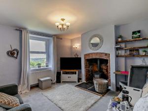 a living room with a fireplace and a television at 3 Bed in Lydbrook 94490 in Lydbrook