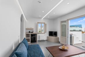 a living room with a blue couch and a table at Mountain and Sea Suites in Kamari