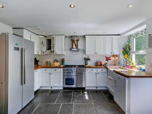 a kitchen with white cabinets and a stove top oven at 3 Bed in Lydbrook 94490 in Lydbrook