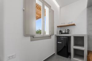 uma cozinha com um frigorífico preto e uma janela em Mountain and Sea Suites em Kamari