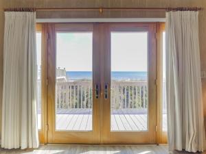 a sliding glass door with a view of the ocean at Pelican Perch in Surf City +26 photos