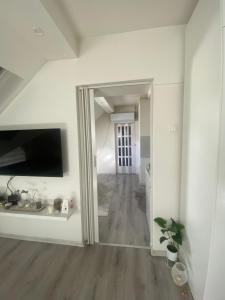 a hallway with a mirror in a white room at Urban Apartment in Sarajevo +4 photos