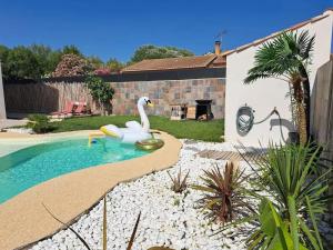 a swimming pool with a swan in a yard at Villa spacieuse et élégante en campagne à Fontvieille offrant sauna in Fontvieille