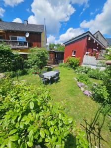 a garden with a bench and a red building at Idyllisches Ferienhaus im Fichtelgebirge in Nagel
