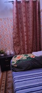 1 dormitorio con cama y cortina roja en MAMA DELIGHT GUEST ROOM en Abu Dabi