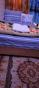 Duas camas com almofadas e um tapete num quarto em MAMA DELIGHT GUEST ROOM em Abu Dhabi