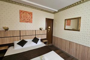 een slaapkamer met 2 bedden en een spiegel aan de muur bij Flamingo Hotel in Piteşti